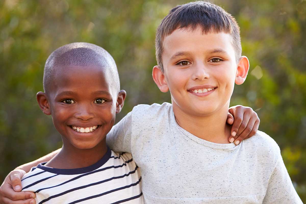 Two friends arms on shoulders smiling